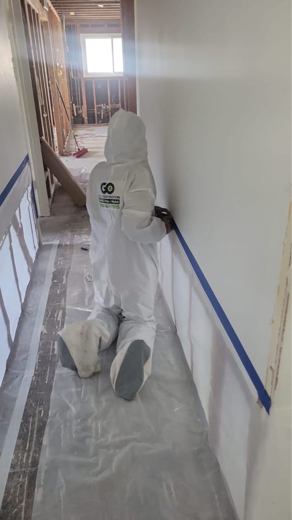 Technician in protective gear during cleanup